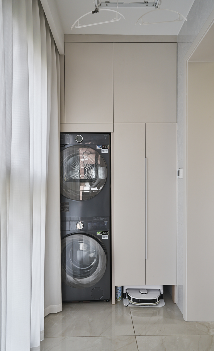 陽臺是晾曬衣物的場所，一側為儲物柜，洗衣機烘干機上下疊加，儲物柜顏色以淡色為主，超大玻璃窗讓陽光柔和的照進來，很舒適、很愜意。