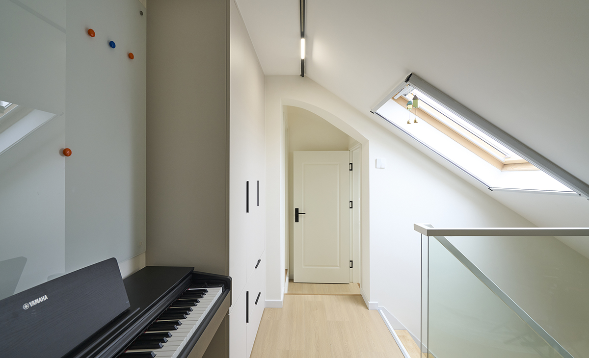 樓上方開個天窗，解決了隔樓的采光問題，玻璃欄桿具有通透性，頂面明裝磁吸軌道燈照亮整個空間，電子琴上面放一塊磁吸書寫玻璃，方便孩子學習功課。