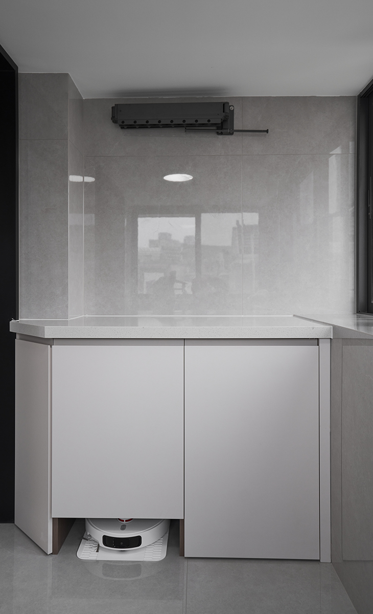 陽臺做旋轉晾衣架架，下面矮柜漏空一定高度，放掃地機器人，解決了收納空間不足的問題，白色大理石窗臺方便主人晾曬。