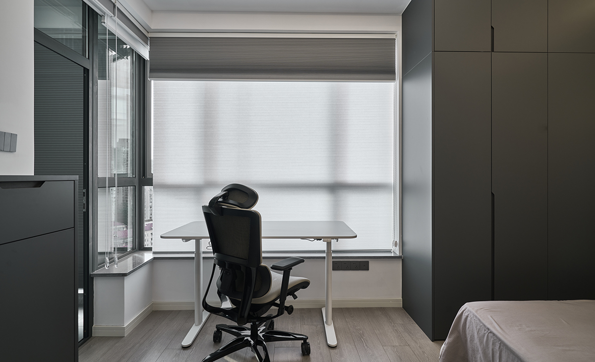 靠著一個大落地窗前安置一個升降的電腦桌，主人的辦公和游戲需求全在這里實現了