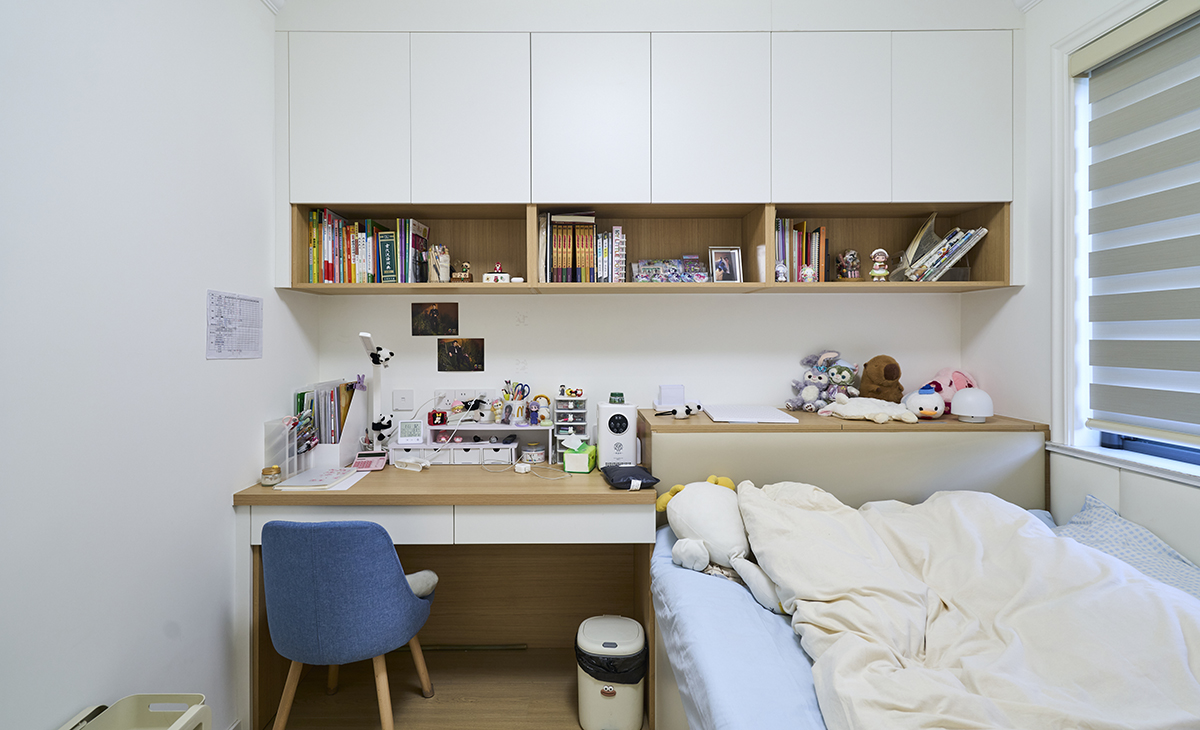 次臥女兒房的設計。采用榻榻米和書桌及吊柜一體的設計
 
-房間左側有一張書桌，書桌上擺放著各種文具和裝飾品，如筆筒、文件夾、書籍和一些小擺件。書桌上方有一個開放式的書架，書架上整齊地擺放著許多書籍和一些裝飾品，包括相框和玩偶。
 房間右側是一張床，床上鋪著淺色的床單和被子，床頭有幾個毛絨玩具，營造出溫馨可愛的氛圍。
窗戶上裝有百葉窗，可以調節光線，既保證了采光，又能在需要時提供隱私保護。
4.?裝飾和細節
 
- 書桌旁邊有一把藍色的椅子，與房間整體色調相協調。
- 書桌下方有一個垃圾桶，方便日常使用。
- 墻上掛著一些裝飾畫和紙張，增添了房間的趣味性。
 
整體來看，這個次臥女兒房設計得非常溫馨和實用，既適合學習又適合休息，充滿了少女的氣息。。
