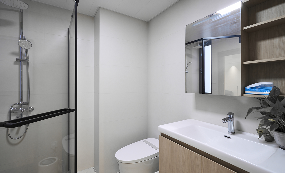 衛生間臺盆柜比較大，儲物空間比較多，原木色臺盆柜，黑色邊框淋浴房，智能馬桶，讓衛生間空間顏色明暗有序，從深到淺，色調很豐富。