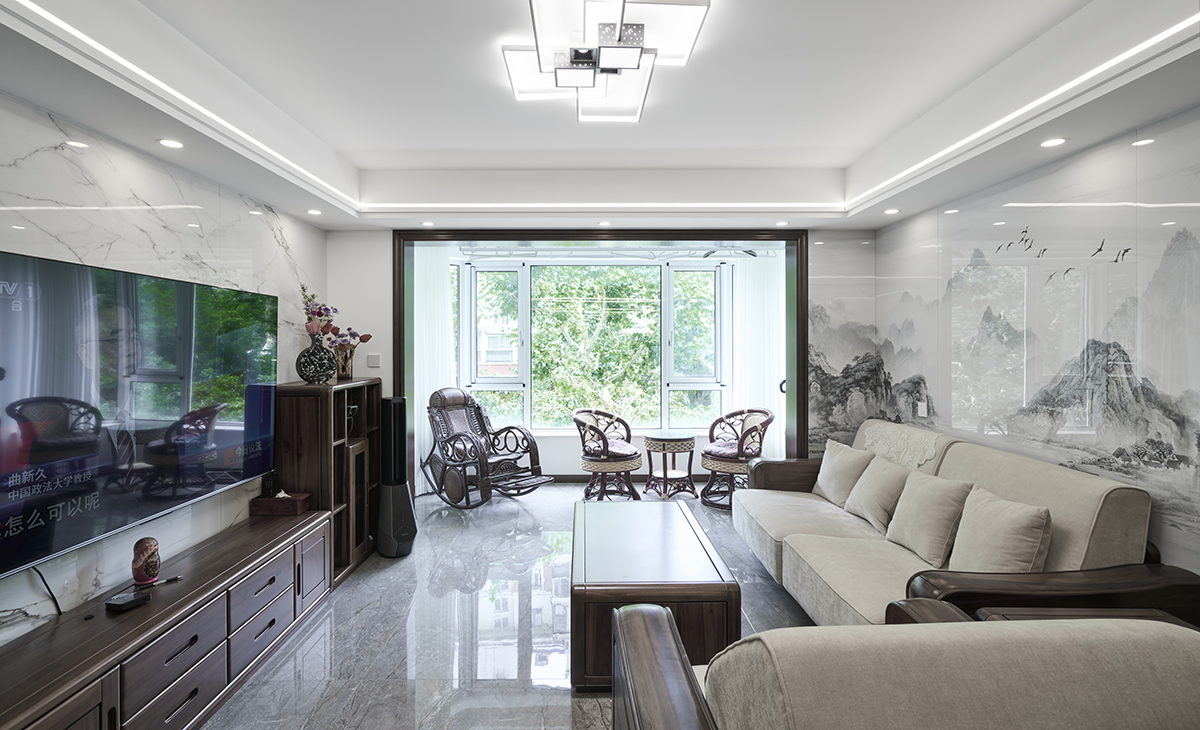 客廳是接待客人的空間、是家庭裝修的亮點所在、也是一家人活動頻率最高的區(qū)域，米色皮質(zhì)沙發(fā)和白色山水畫巖板相呼應(yīng)，體現(xiàn)高端華貴，吊頂造型上采用方形石膏板+雙眼出線型燈，實木電視柜和茶風(fēng)、條幾上放一裝飾擺件。地面采用灰色玻化地磚。造型和色調(diào)上無不體現(xiàn)新中式風(fēng)格的厚重和高貴。