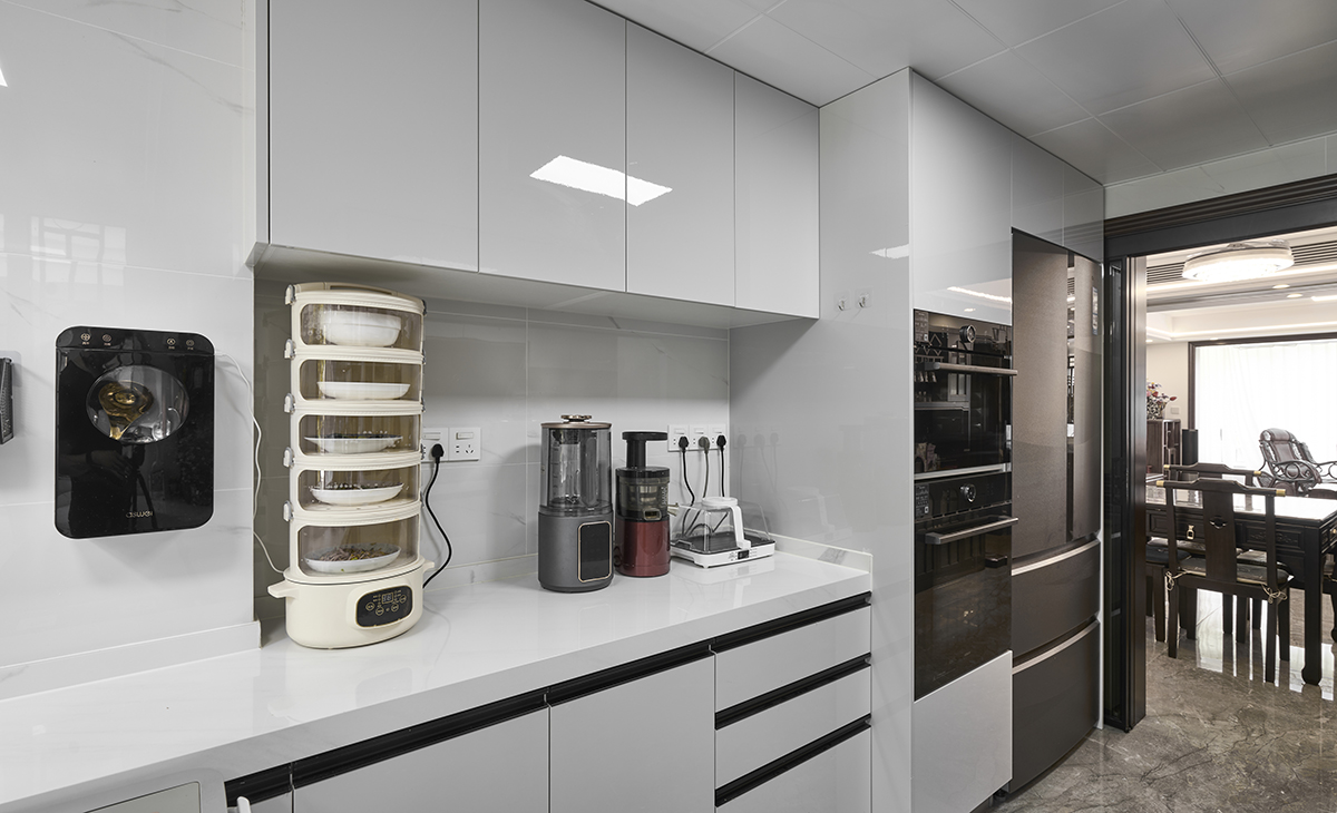 嵌入式冰箱和電器立柜完美組合，廚房移門可以全部收起來。深咖色地磚通鋪，白色臺面，讓廚房空間顏色明暗有序，從深到淺，色調(diào)很豐富。