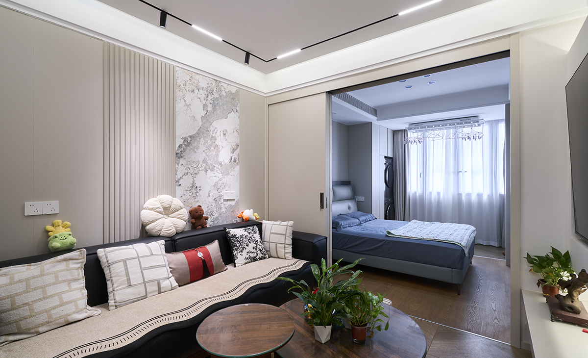 客廳是接待客人的空間、是家庭裝修的亮點所在、也是一家人活動頻率最高的區域，黑色皮質沙發，體現高端華麗，吊頂造型上采用懸浮石膏板+內嵌燈帶，奢華氣息很濃。地面采用木紋地磚，沙發背景采用皮質+實木護墻板。造型和色調上無不給人華麗、高貴、溫馨的氣息。