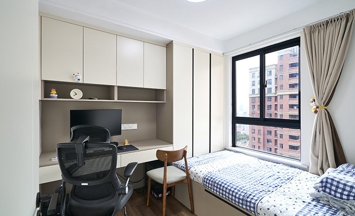 次臥空間不大，整體做了大衣柜加榻榻米床及連體寫(xiě)字臺(tái)書(shū)柜，增加很多儲(chǔ)物空間，拿放也很方便，雙人位寫(xiě)字臺(tái)滿(mǎn)足了以后小孩陪讀的功能需求，主人很是喜歡。
