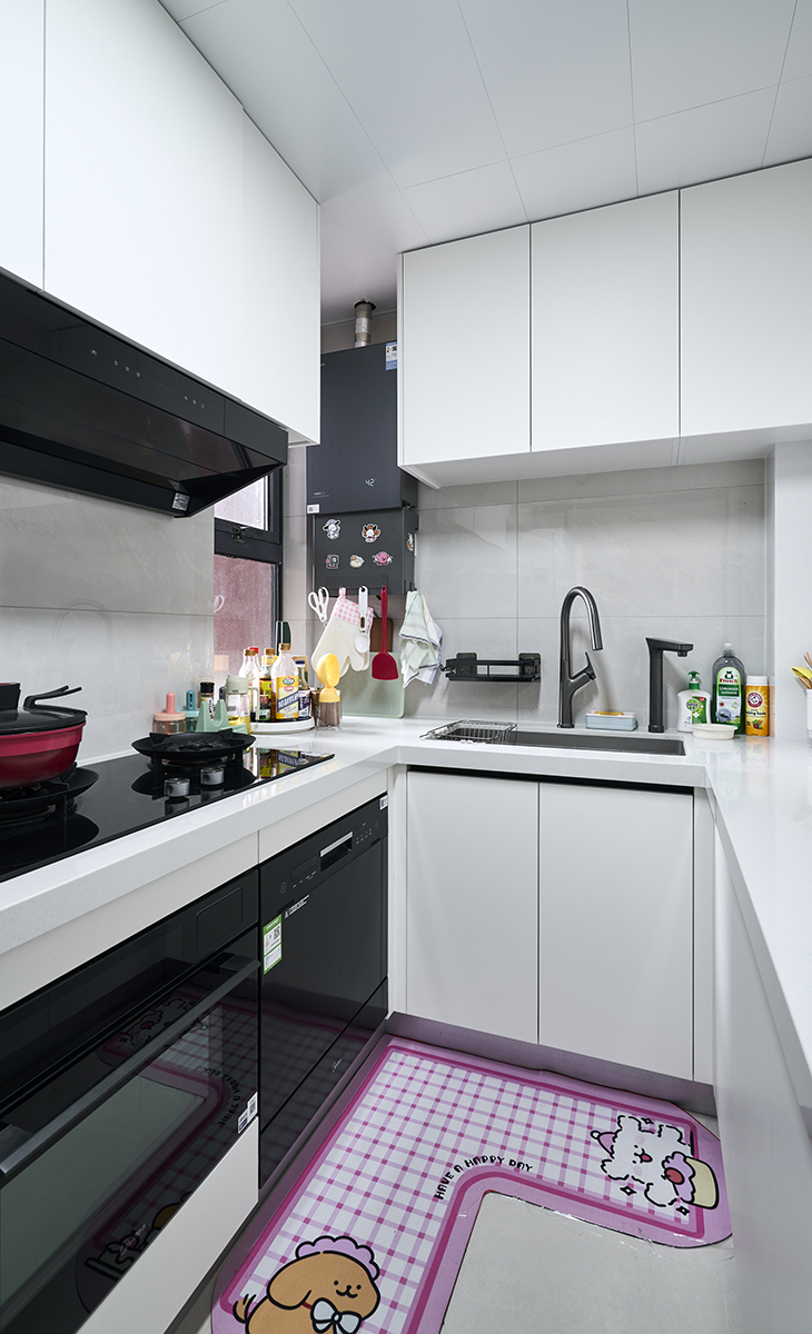 該套房子廚房是開(kāi)放式，做成U字型櫥柜，煤氣灶下方配洗碗機(jī)和蒸烤箱，上柜下柜儲(chǔ)物空間滿(mǎn)滿(mǎn)當(dāng)當(dāng)，臺(tái)面巖板，方便打理，墻地磚的顏色和櫥柜顏色搭配地很自然，客戶(hù)不斷地夸贊設(shè)計(jì)師對(duì)色彩的精準(zhǔn)把握。