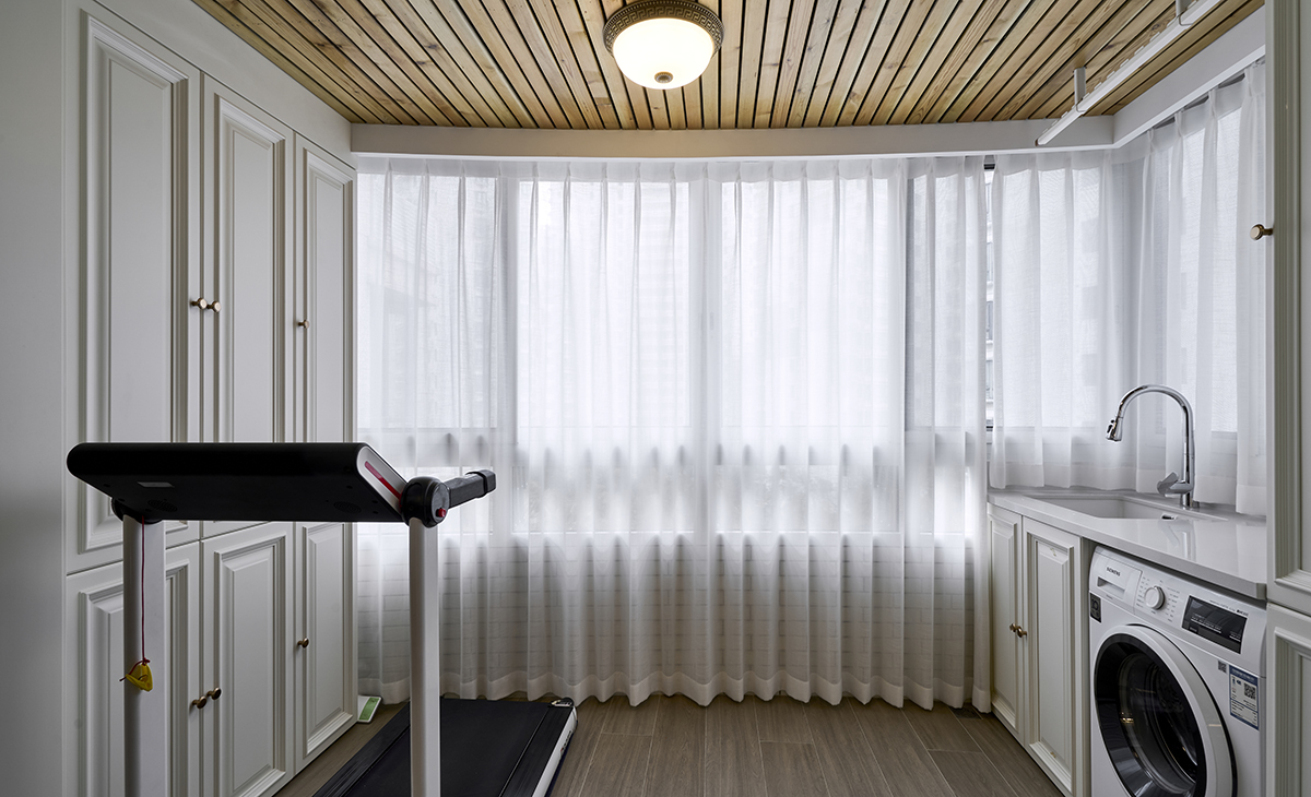 該套房子陽臺的空間利用的很完美，定制洗衣機柜，儲物空間很大，有一個小水池也能洗洗小東西，上面做一個吊柜，留一開放格放經常用的物品，使用起來很方便，把空間襯托的完美無瑕。