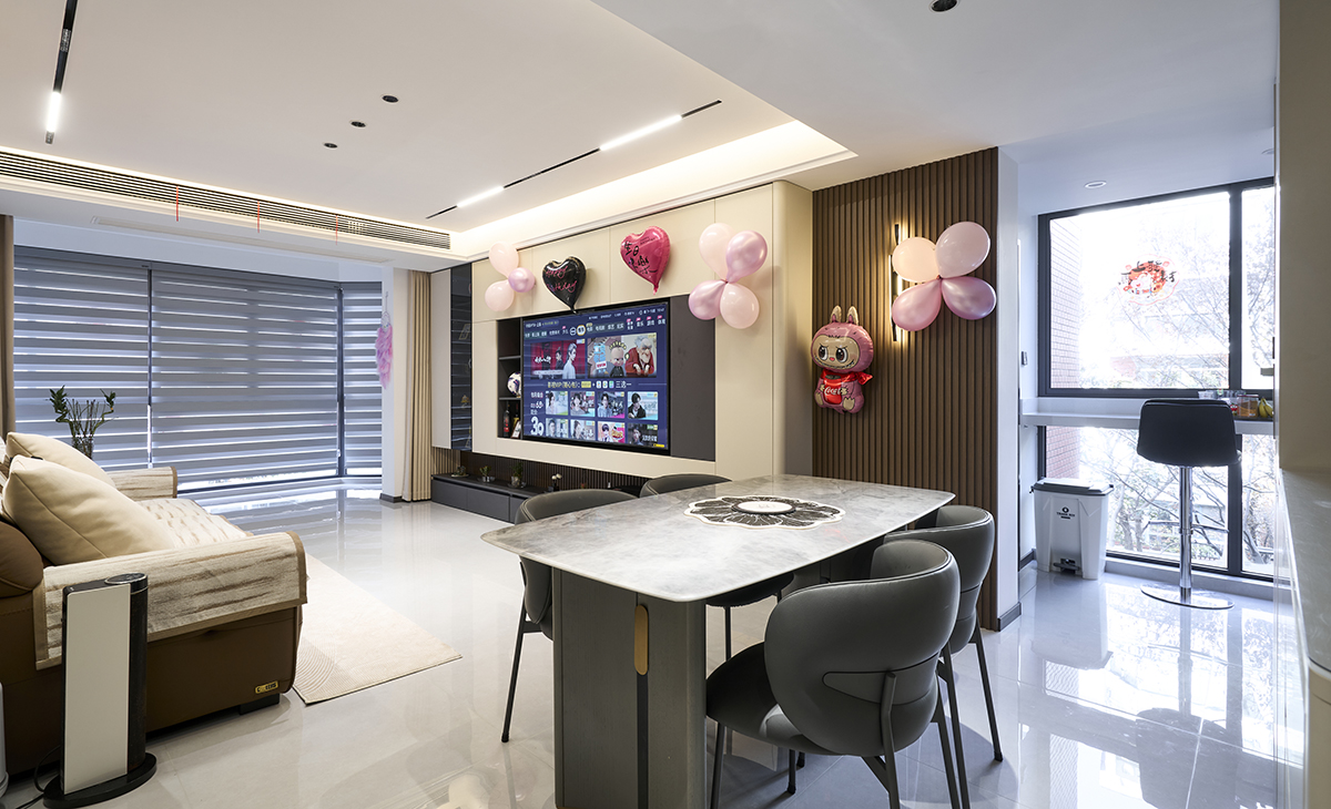 客廳是接待客人的空間、是家庭裝修的亮點所在、也是一家人活動頻率最高的區(qū)域，棕色皮質沙發(fā)，體現(xiàn)點亮空間，吊頂造型上采用無主燈設計+磁吸軌道燈，極致簡約的氣息很濃。地面采用淺灰色地磚，沙發(fā)背景采用竹木木飾面墻板。造型和色調上無不給人華麗、簡約、溫馨的氣息。