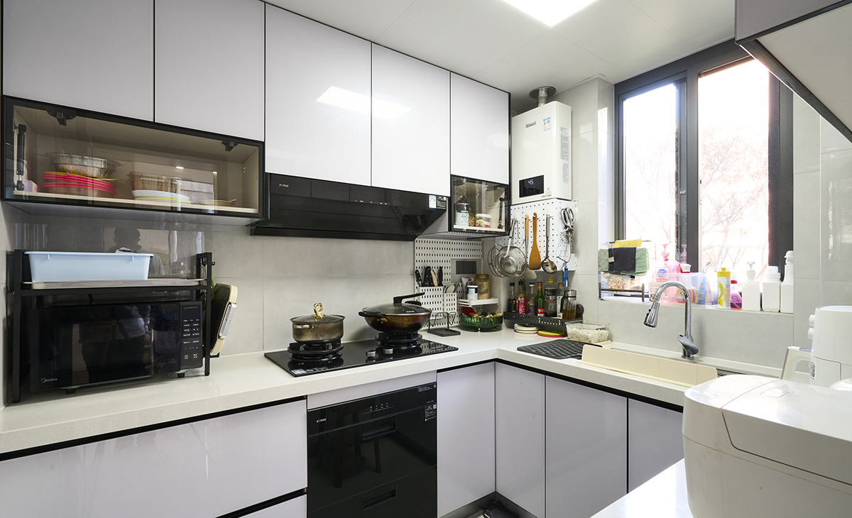 該套房子廚房空間很大，做成U字型櫥柜，蒸烤一體機放煤氣灶立柜中，煤氣灶下方配洗碗機，上柜下柜都是米白色，臺面白色，方便打理，墻地磚的顏色和櫥柜顏色搭配地很自然，客戶不斷地夸贊設計師對色彩的精準把握。
