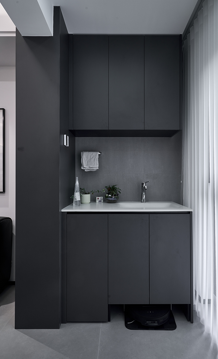 銜接整體空間的現代暗調風格，以 “家政功能 + 輕休閑” 為核心，將陽臺打造為 “隱形家政區 + 小型放松角”，既滿足日常家務需求，又兼顧空間美學。