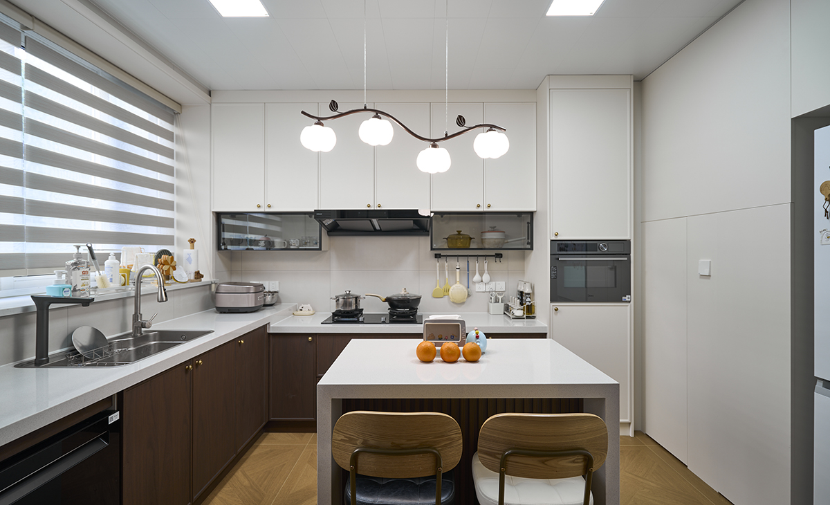 胡桃木裹著暖光，黃銅拉手碰著煙火廚房，是復古調里的人間煙火氣。
百葉窗篩碎的光，落在樹枝吊燈的奶白球上，連洗個碗都像在復古電影里。