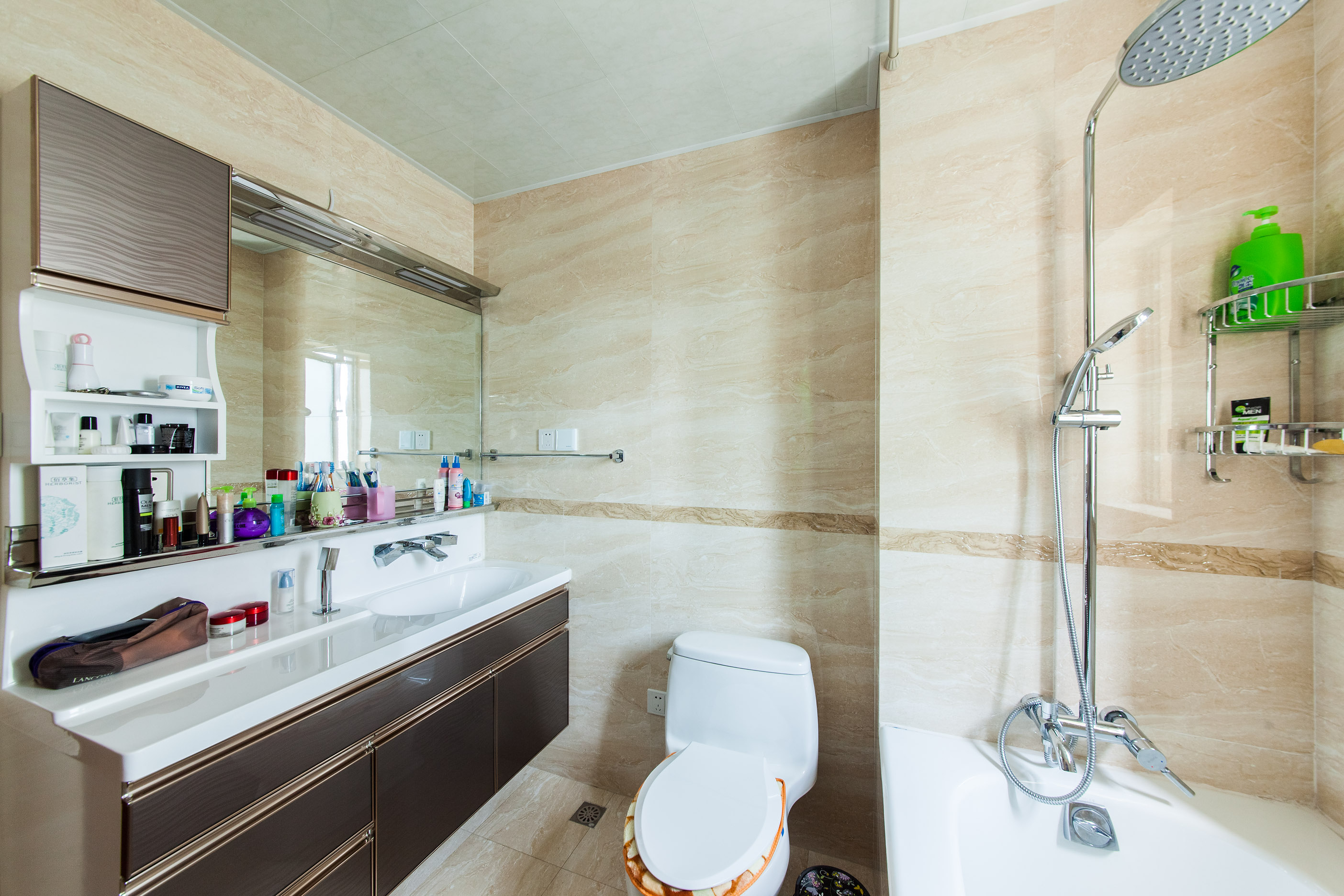 衛生間運用大理石文理的墻面磚，淺黃的磚，搭配上深色的臺盆柜，在滿足生活需求的同時，又不失現代簡約的設計基準。