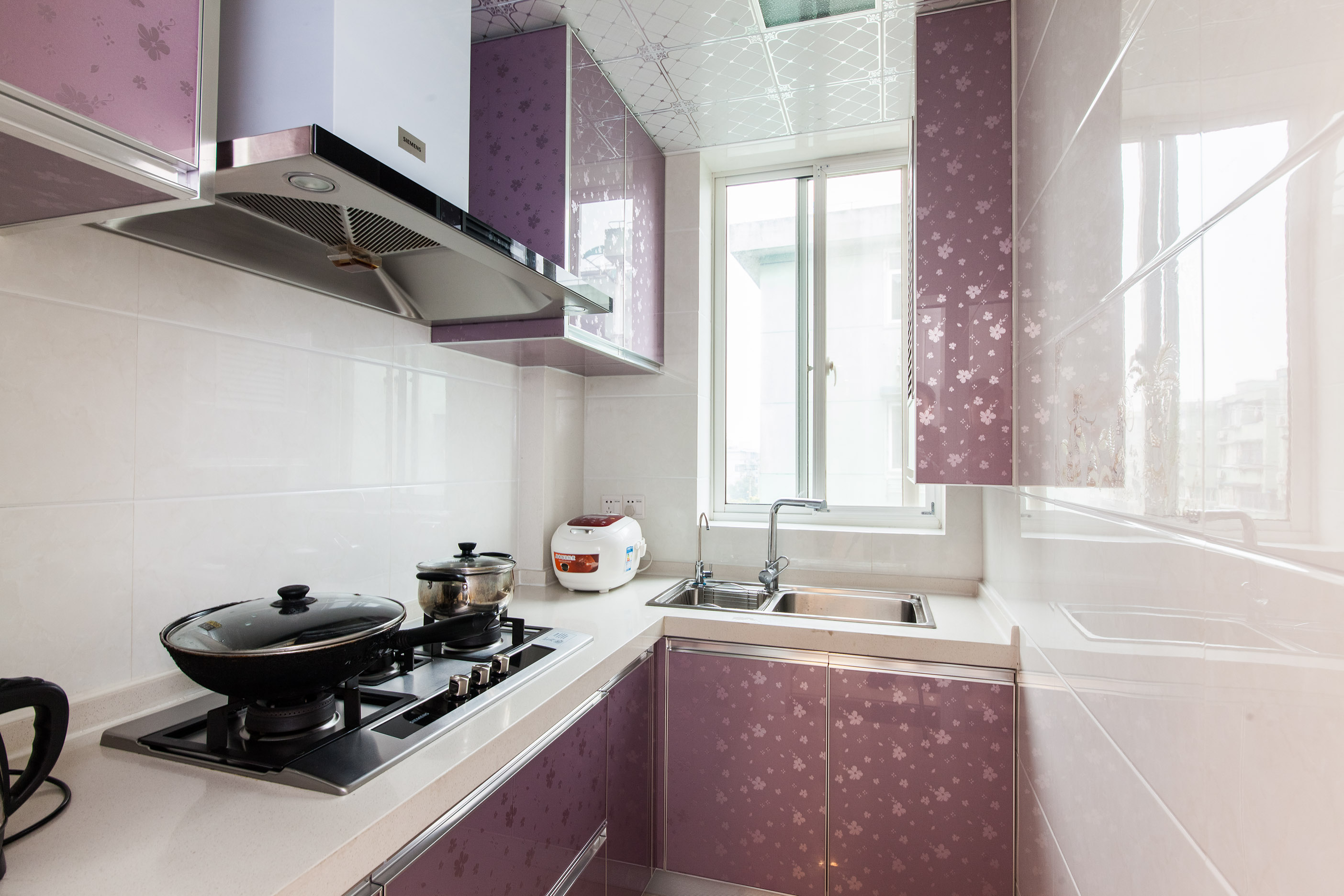 白色的墻磚，色彩鮮艷的廚柜點綴其中，使狹窄的廚房顯得寬敞明亮，主人在做飯也是一種享受。