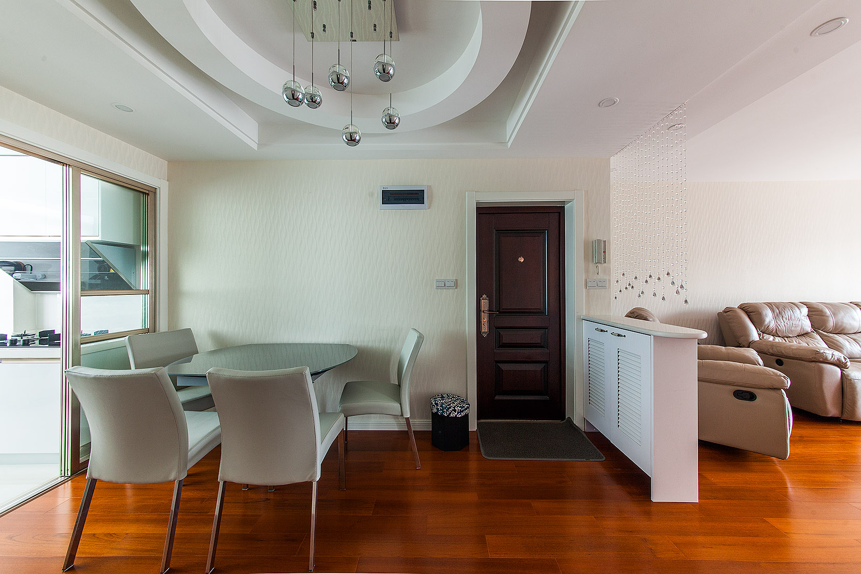 餐廳吊頂現代而別致，米色餐椅與玻璃餐桌，溫馨而干凈。
