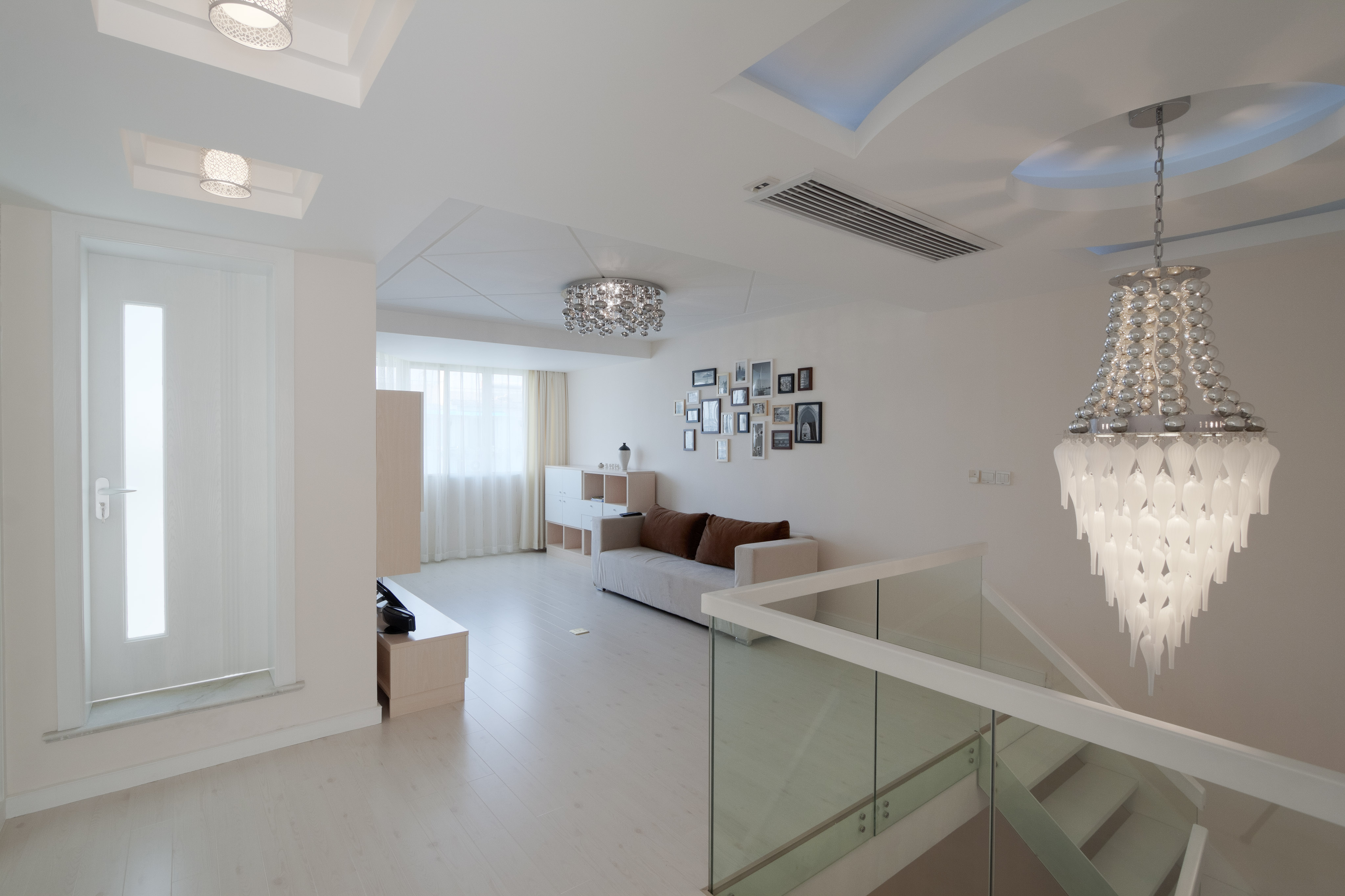 淺色調的色彩搭配，精致的照片墻，個性的樓梯水晶吊燈，凸顯了硬裝與軟裝的完美融合。
