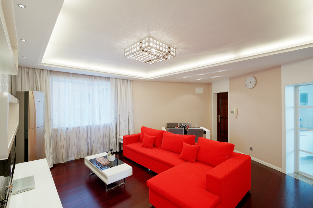 客廳原本不規則的房型在吊頂的借助下，把客廳功能有序規整，米色墻面碰上靚麗的沙發色，碰撞出時尚的火花。
