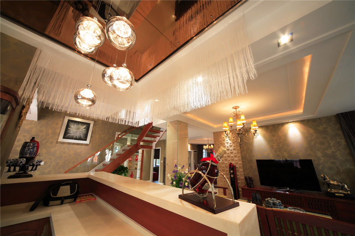 客廳整體風格采用木，鏡，沙風格，是當下比較時尚也是板式的處理方式，在顏色上做了統一，配上精致的玻璃燈和線簾的裝飾，把板式的硬線條做了軟性富有穩重。
