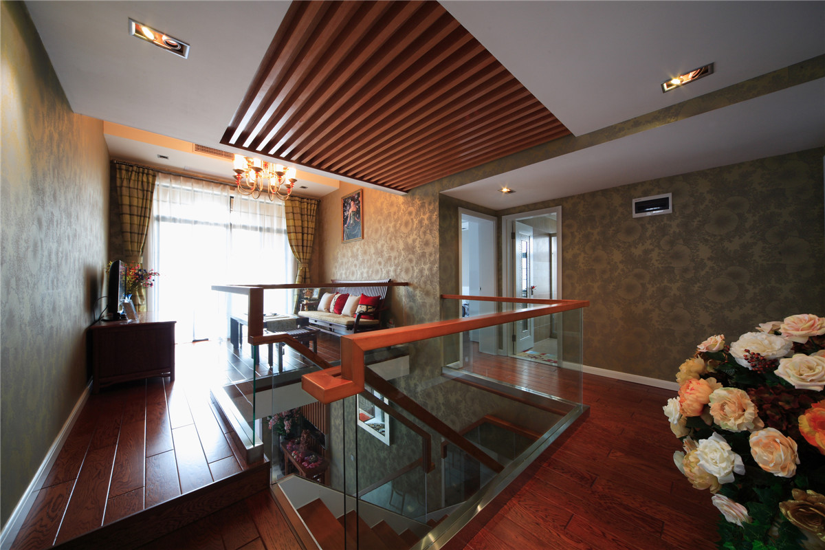 二樓的樓梯采用了鋼化玻璃和木結構，摒棄了傳統的實木結構，既時尚又大氣，配合著頂面的木飾面吊頂，相得益彰。