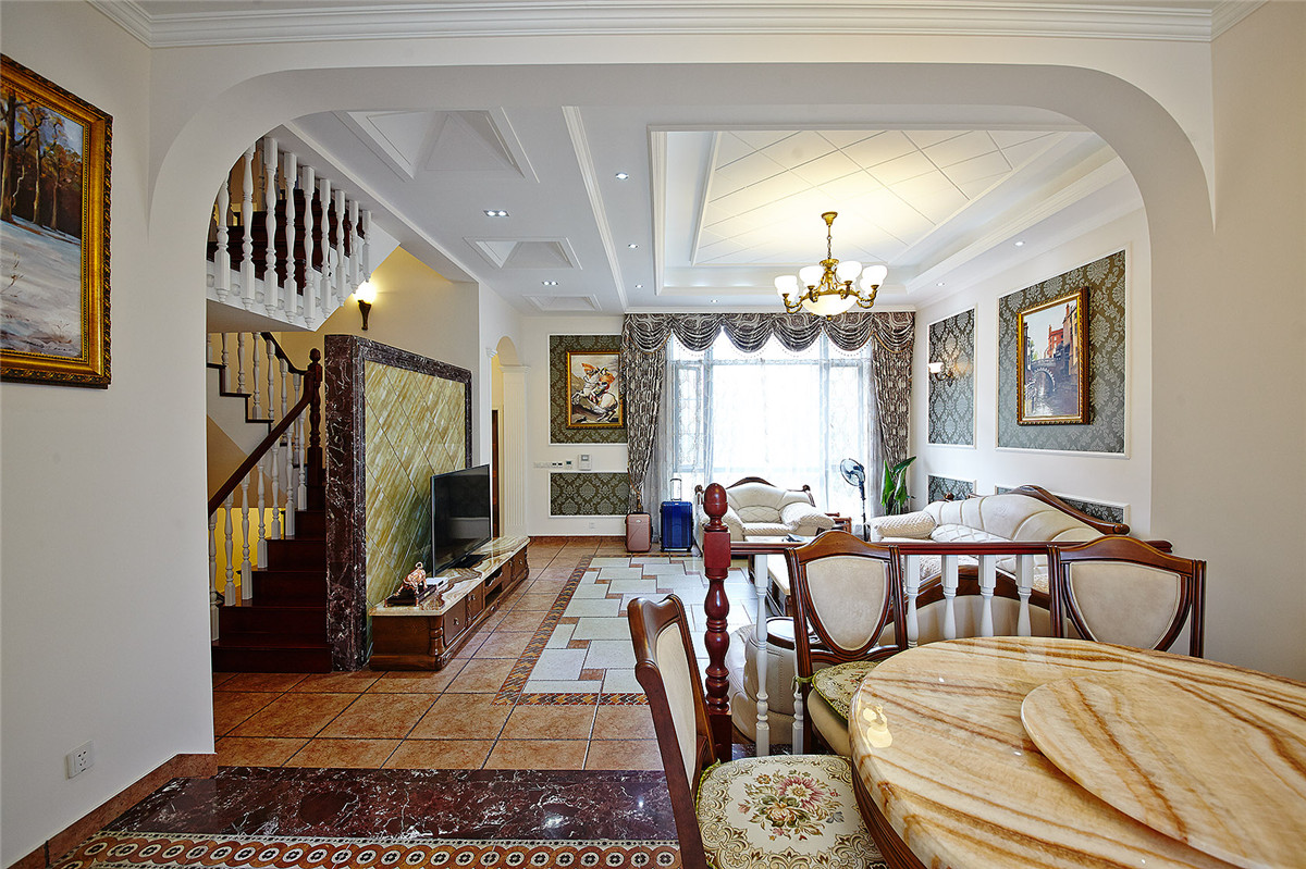 客廳與餐廳相鄰，為業主就餐和休閑會客提供了方便。古銅吊燈的裝飾帶給空間的是飽和的色彩。墻體的造型被精心設計的。
