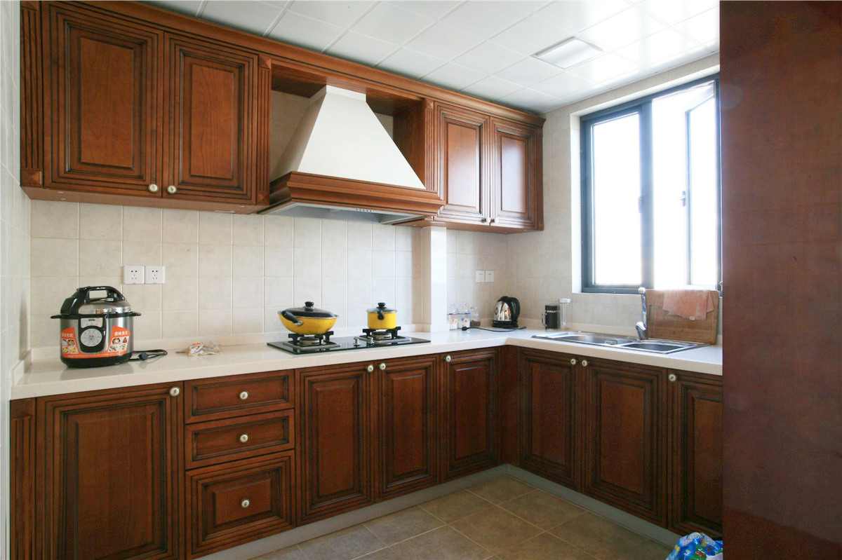 廚房間的整體櫥柜都有著西式的風味，而且還帶有西式田園風格。潔白的臺面，吸油煙機的半露再有邊框裝飾，就更加突出了。
