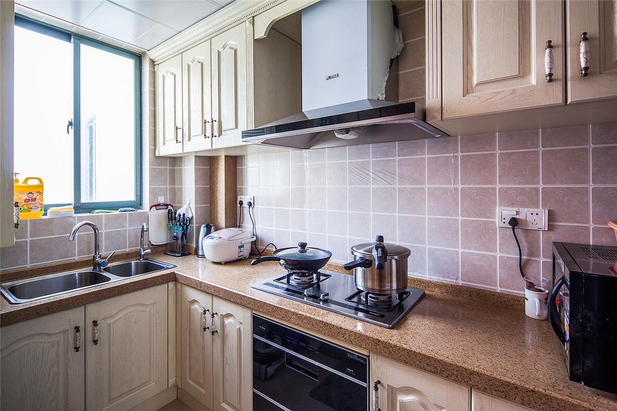 簡歐大氣、更貼近于自然，白色實木廚柜配套歐式墻磚，保留了材質、色彩的一致。
