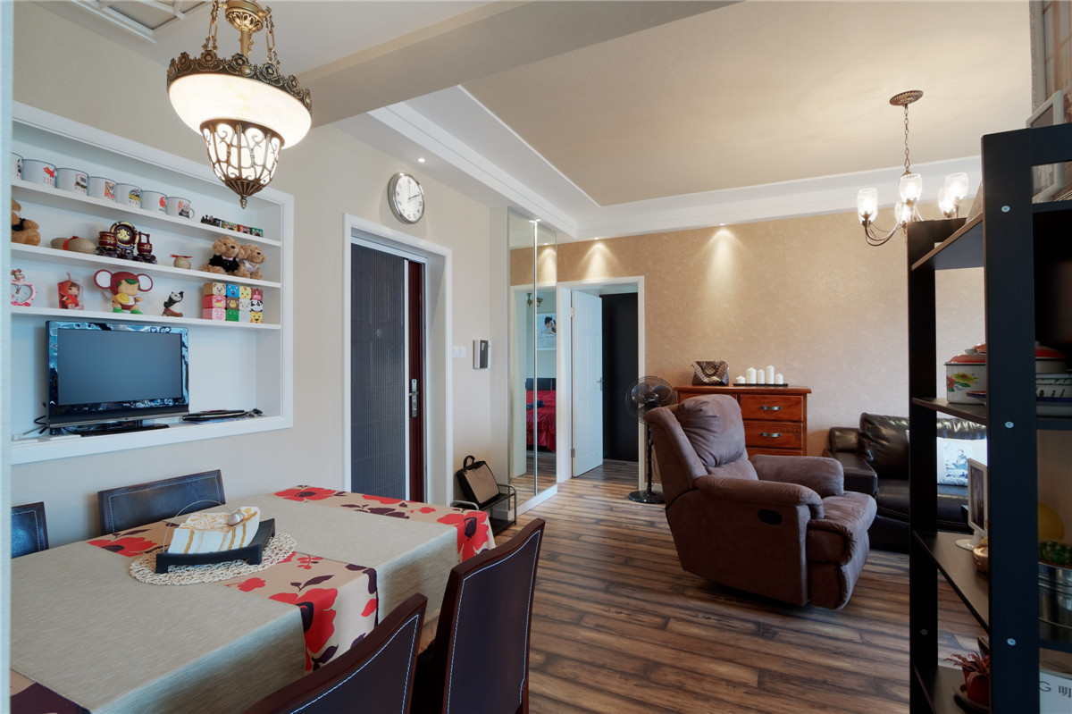 客廳進門處的裝飾架上擺放著業(yè)主自己的小收藏，在用餐時也能愜意的看看電視，這種氛圍正式給工作勞累了一天的年輕人最好的放松。
