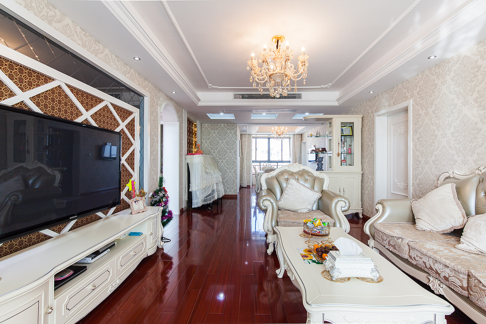 墻面暖色壁紙的處理，頂面角花的點綴還有電視背景細節的處理，把歐式細膩的味道烘托出來。
