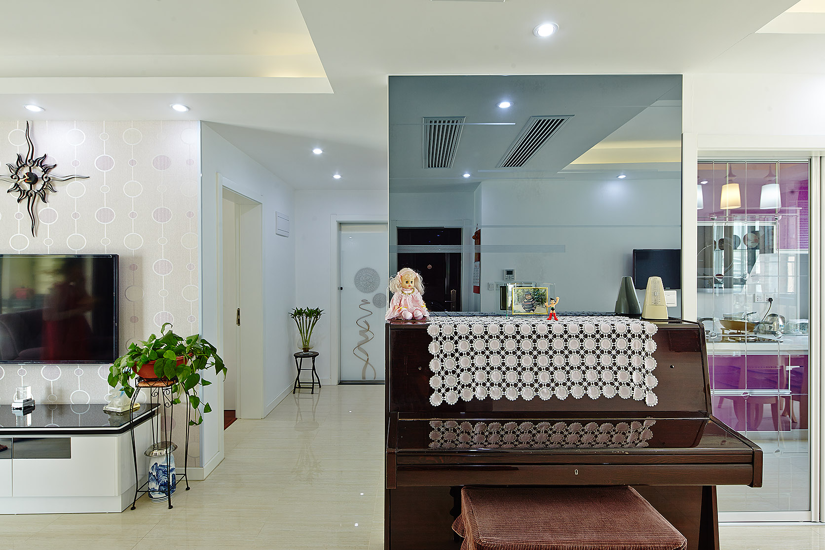 由于房型關系，進門右邊就是餐廳，設計師利用對面的灰鏡和鋼琴分割客餐廳的區分，為本來沒有辦法分割的區域巧妙的劃分了一下，完全不占用空間。更使空間寬敞而亮麗。