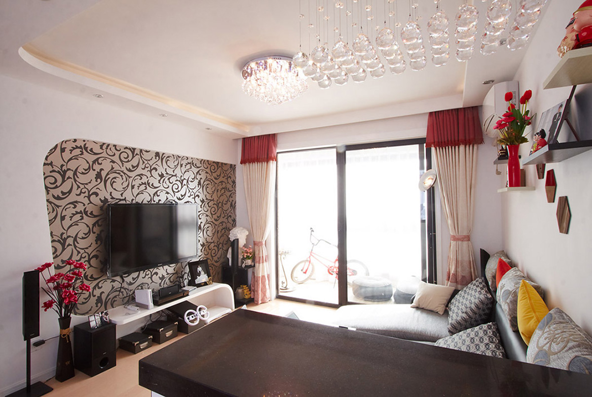 灰色布藝沙發簡潔、時尚，弧形的背景墻與弧形的電視柜，再配上灰色花紋墻紙，整體視覺顯得大氣而時尚。
