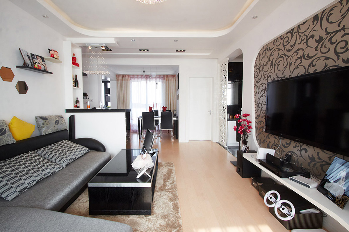 餐廳的家具與客廳形成呼應，吸人眼球的要數客廳的吧臺，也以黑白為基調，配上水晶燈，讓客廳的空間盡顯時尚。
