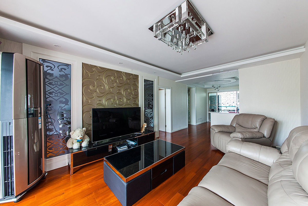 客廳最大的亮點，無疑是背景墻，金色墻紙沖淡了灰鏡與白色烤漆這個萬能組合，所衍生出的冷峻氣息，使得客廳永遠不令人感到單調枯燥。