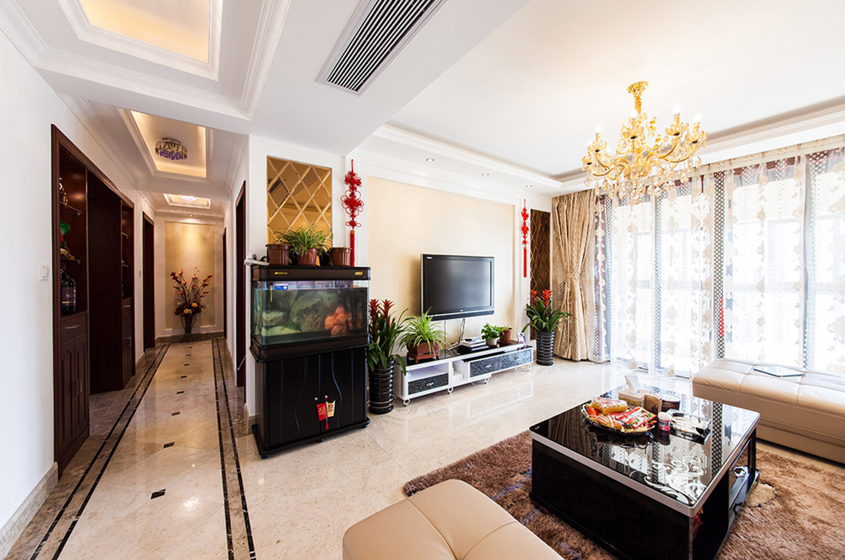 鏡面的巧妙利用使得客廳的整體空間視覺加大，漂亮的水晶吊燈，深色的茶幾給人一種輕飄而又穩(wěn)重的視覺感受。