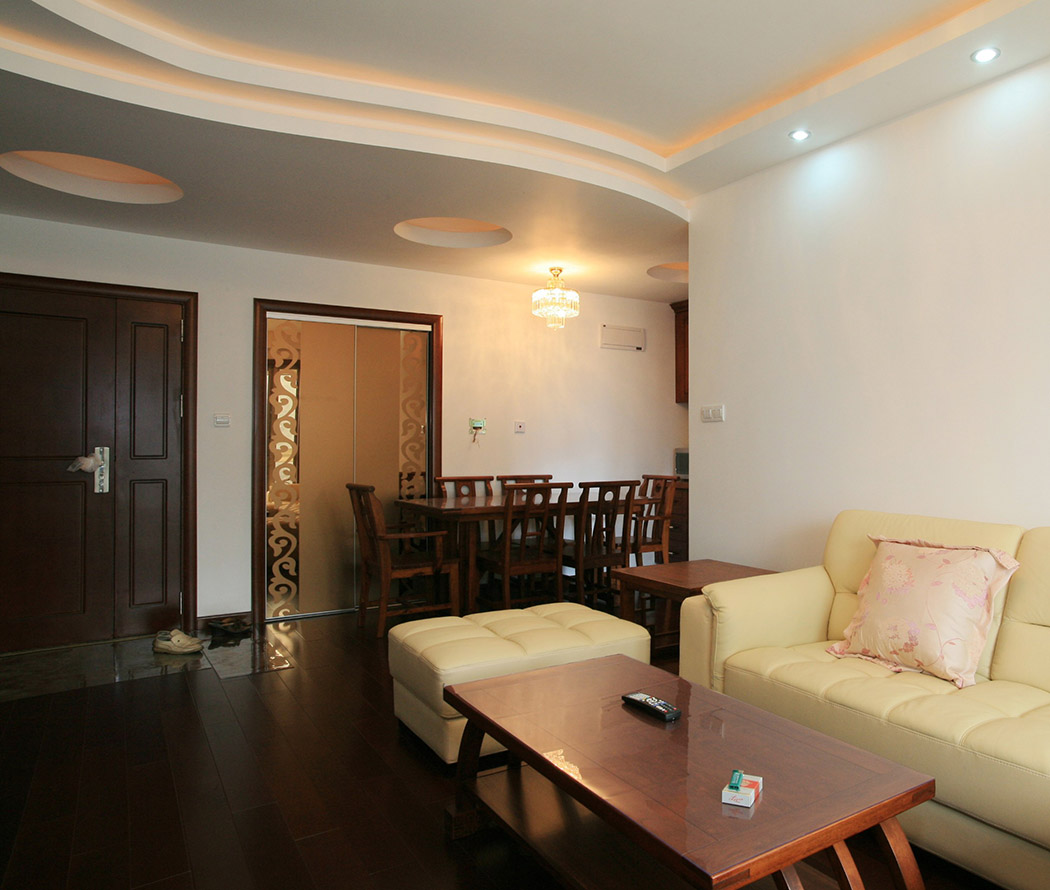 客廳轉(zhuǎn)入餐廳一兩步，餐廳一套中式的餐桌；頂部做了弧形吊頂，再以大小圓給頂部做些
