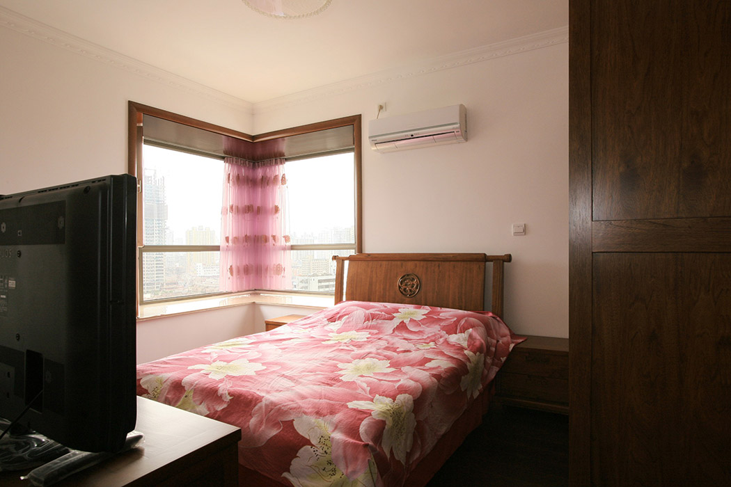 臥室里以白色為主色調(diào)，一張中式的床，加上兩只床頭柜