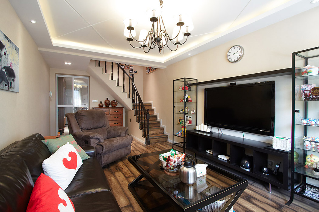 客廳整體的地板以做舊為元素，突出整體懷舊風格，沙發(fā)采用皮質(zhì)感，色系統(tǒng)一。
