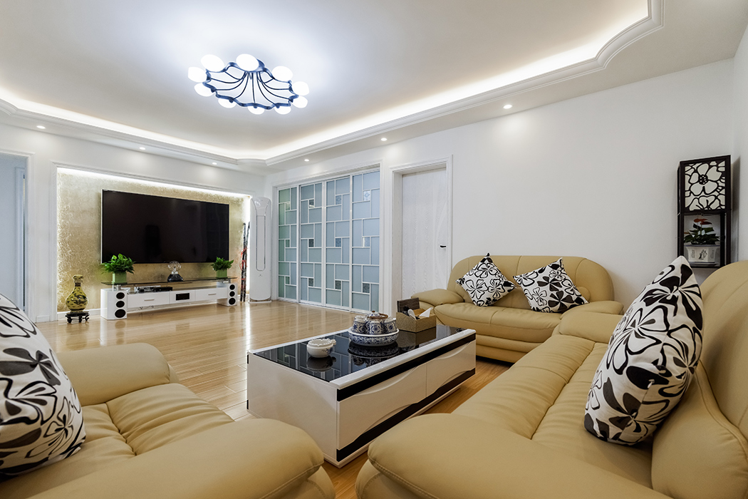 客廳為了配合業主家的米色沙發，地面采用了淡色系的復合地板，家具采用黑白系列，簡單干凈。沒有過多的裝飾，通過頂面的弧線設計，讓整個客廳顯得不那么單調。
