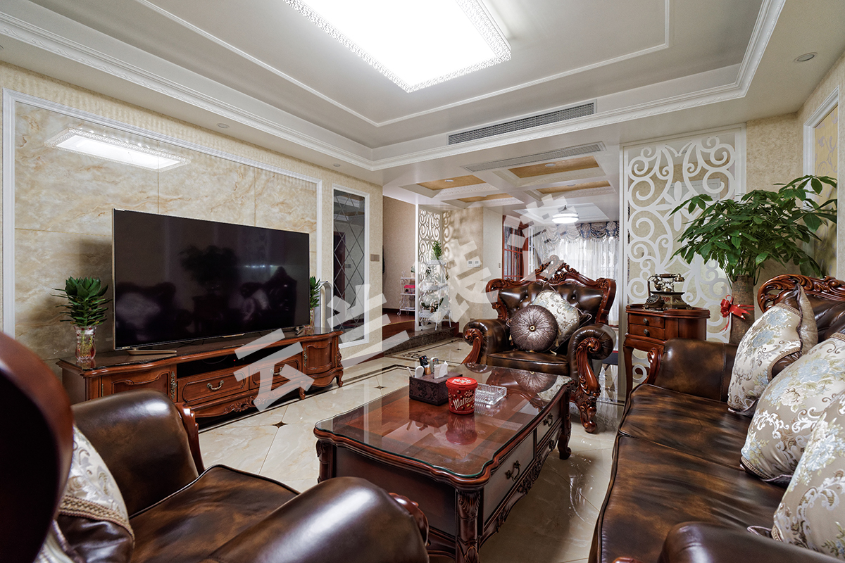 客廳為了襯托沉穩大氣的深色家具，客廳采有光潔大氣的地磚，使得深色家具不再壓抑，也更凸顯了家具的質感，品質生活油然而生。歐式家具低調而奢華，沉穩而大氣，充分體現了業主的，低調而內斂的做人風格。電視背景墻的線框采用的實木線條，中間采用的是當下比較流行的微晶石，兩邊菱形抽邊境，顯得端莊大氣。
