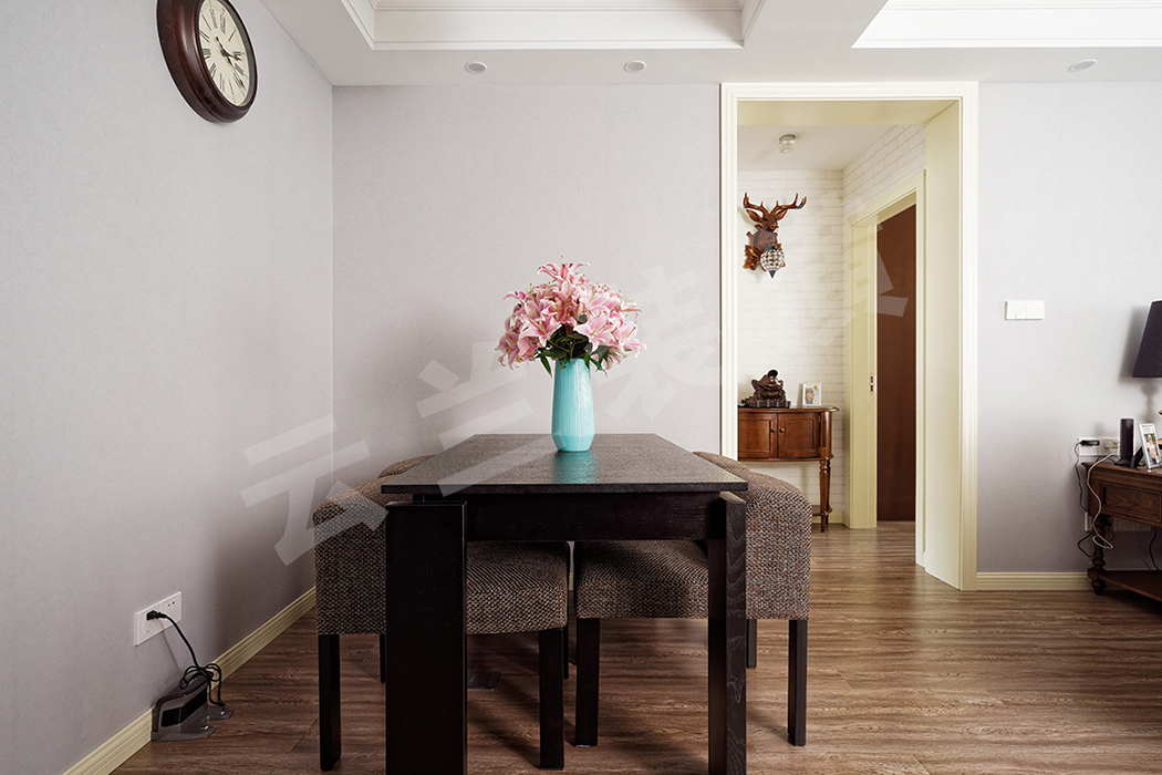 簡易的藍(lán)灰色壁紙，簡易的木質(zhì)餐桌和布藝餐椅，一只花瓶作為小小的點綴，一切恰到好處。
