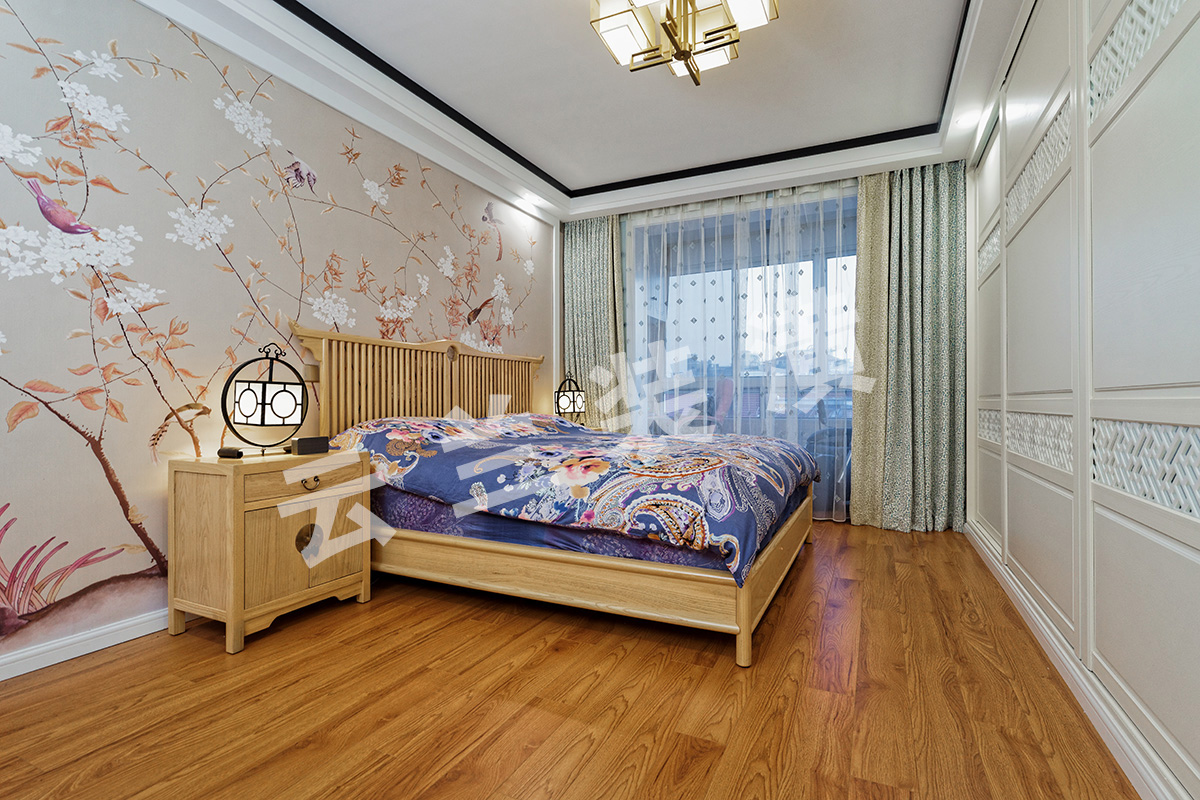 主臥沒有做過多的裝飾，床頭背景墻用的暖色花鳥畫壁紙，中式味十足，給人以溫馨自如的感覺！搭配上布藝窗簾，摒棄傳統的大紅大紫，淡淡的粉色配上淡淡的綠色，不但沒有使人覺得尷尬，反而讓人覺得溫馨，自然。這樣的搭配潛移默化中柔化了家具的硬朗，配上淡色系的床藝，讓整個臥室溫馨而不失新中式典雅、端莊的感覺。
