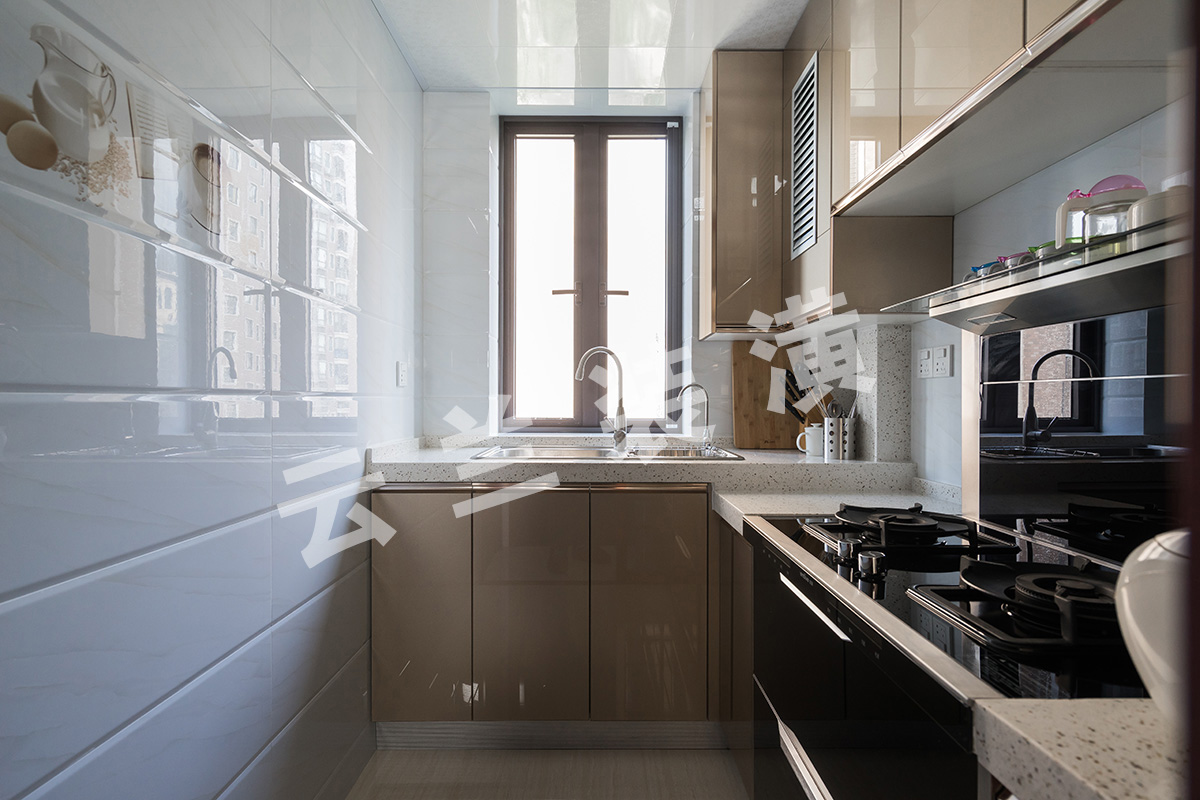 廚房瓷磚采用淺色打底，凸顯廚衛(wèi)，使空間看上去更有層次。櫥柜采用的香檳色晶鋼板，方便打理也更加耐用，房東灶具選用的一體集成灶，功能集成，空間更高效
