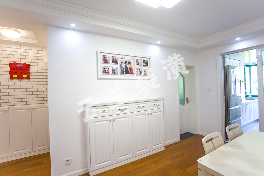 餐邊柜嵌在墻體中的不僅美觀還更實(shí)用。柜上的墻面，也由滿滿的愛意鑲嵌在對(duì)方心中的照片點(diǎn)綴。
