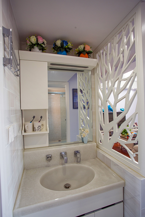 原本衛生間正對大門，考慮到整體的風水，利用狹長的過道做了個干區，鏤空花格增強了視覺效果以及通透性，衛生間簡單大方，凸顯空間感。
