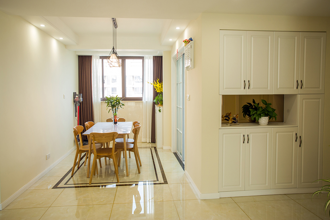 餐廳與北陽(yáng)臺(tái)打通使餐廳空間更加寬敞明亮，原木餐桌清新自然，增添了幾分食欲。過(guò)道裝飾柜也不但增加了儲(chǔ)物空間還使過(guò)道深度不會(huì)顯得那么突兀，給居家?guī)?lái)一份溫馨感
