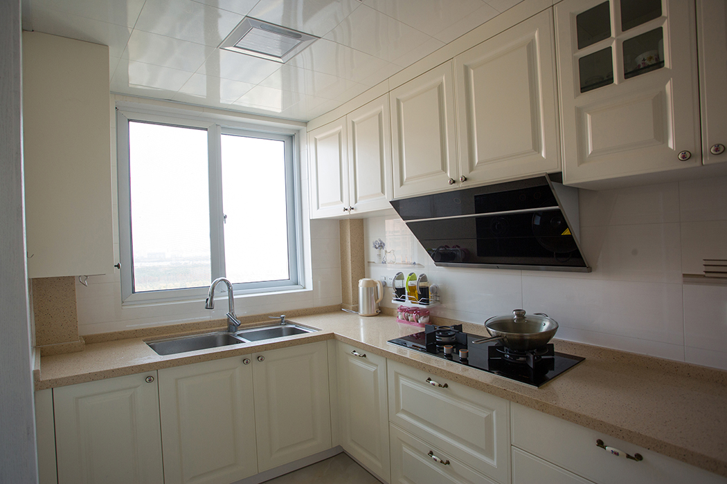 廚房空間較大，墻面白色墻磚，干凈明亮，暖白色的廚柜搭配米黃色的臺(tái)面，干凈而舒適，讓男主人也有了愛(ài)上燒飯的理由。
