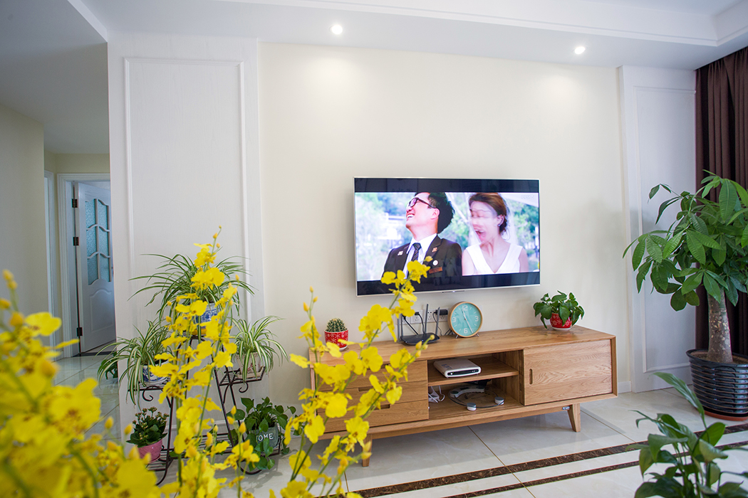 客廳的背景墻采用了護(hù)墻板作裝飾，為極簡(jiǎn)的背景墻增添了幾分神秘與現(xiàn)代感，深色的家具低調(diào)奢華