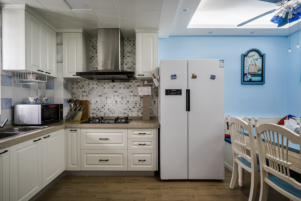 廚房延續了餐廳的簡潔風格，開放式廚房，采用卡座的設計，與木質餐桌椅形成呼應關系。背景和弧形吊頂的選用，與客廳保持一致性，形成空間的完整性與整體感。
