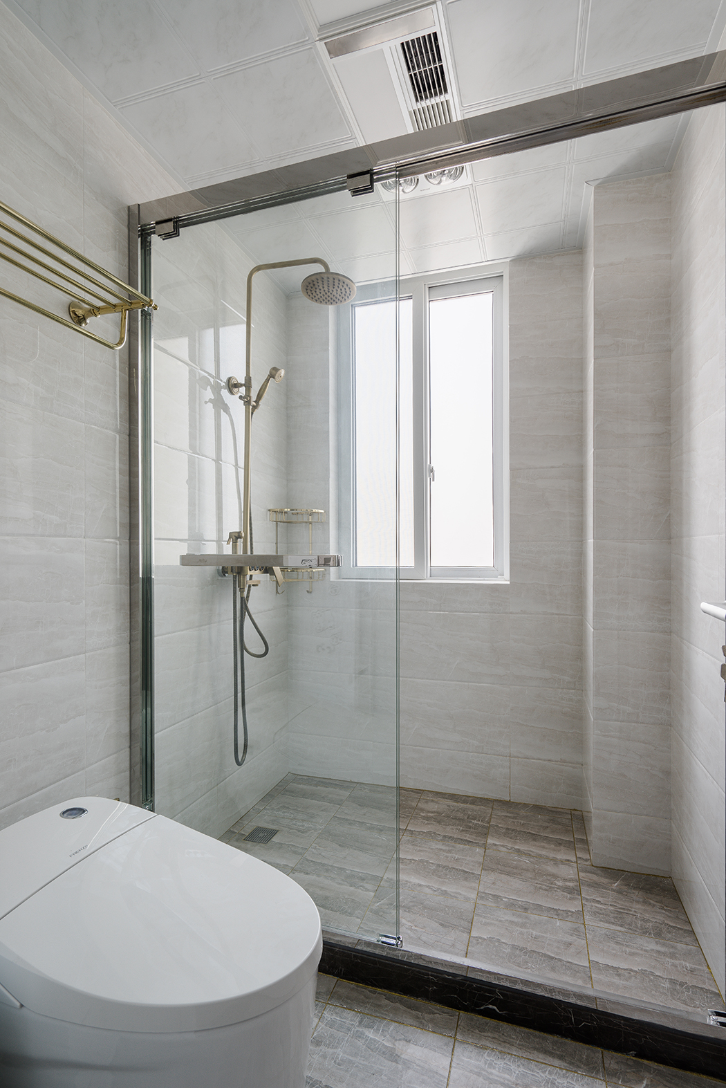 衛生間，則是簡單的材質對比，襯托出每種材質特有的性格和溫度。如原木色的臺盆柜、半透明的不銹鋼夾絲玻璃，都有它們特有的屬性。干濕區的過渡也不會對采光造成影響。值得一體的是臺盆柜上方的鏡前燈，簡潔明了，臺盆柜下端的這部分空間更是合情合理的考慮了衛生的清理。
