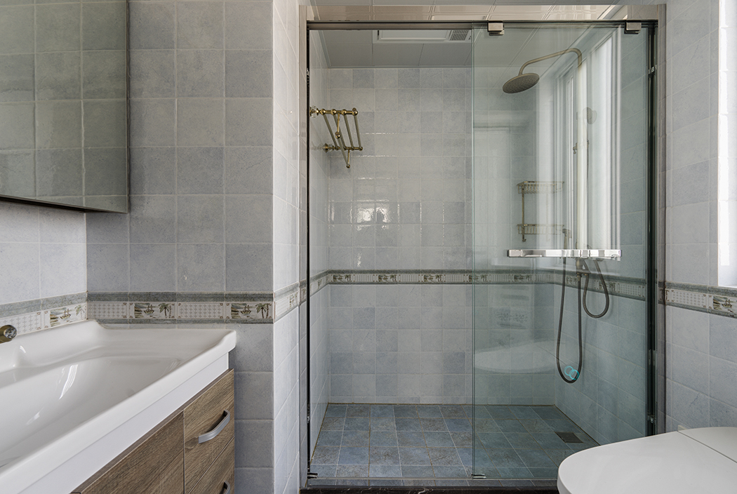 衛生間，則是簡單的材質對比，襯托出每種材質特有的性格和溫度。如原木色的臺盆柜、半透明的不銹鋼夾絲玻璃，都有它們特有的屬性。干濕區的過渡也不會對采光造成影響。值得一體的是臺盆柜上方的鏡前燈，簡潔明了，臺盆柜下端的這部分空間更是合情合理的考慮了衛生的清理。