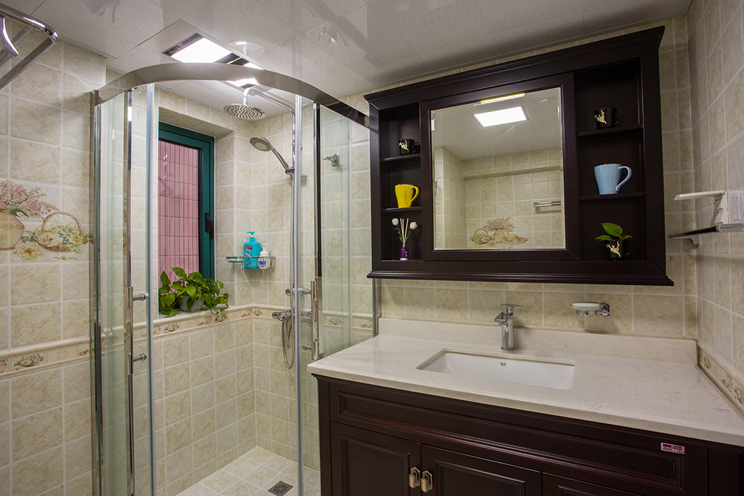 衛(wèi)生間淺色米黃墻磚上下過度的腰線都透露出精致生活的向往，古典風(fēng)格的實(shí)木浴室柜大氣沉穩(wěn)，處處可見的綠色植被，使得家中處處生機(jī)勃勃。
